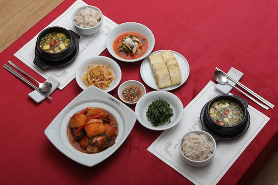 由大麦饭、大酱汤、青花鱼土豆、萝卜缨泡菜、凉拌苋菜、凉拌豆芽和煎豆腐组成的“青黄不接”饭桌。-- 中韩人力网