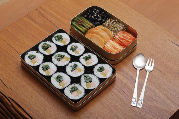 由紫菜包饭、蒜苗、酱菜、炒鳀鱼、酱黄豆、辣白菜和香肠组成的初创期盒饭。 --- 中韩人力网