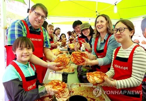 2016蔚山瓮器庆典上，多元文化家庭成员们在体验用传统瓮器保存泡菜。中韩人力网