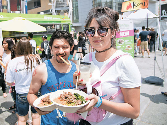 来到活动现场的游客正在品尝“Bibigo”快餐车上销售的韩国美食。----  中韩人力网