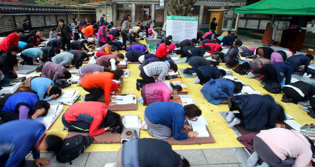 韩国高考，家长跪地为孩子祈福。----中韩人力网